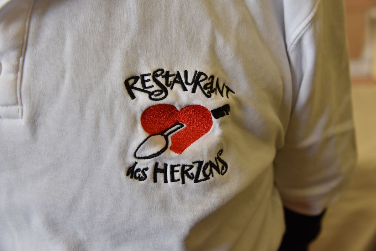 Auf ein Hemd gesticktes Symbol des Restaurants des Herzens