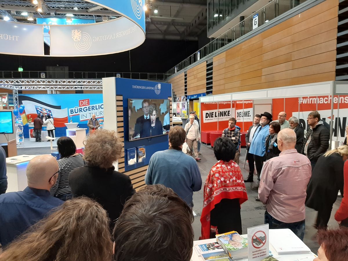 Besucher der Thüringenausstellung verfolgen die Wahl des Ministerpräsidenten am Stand des Thüringer Landtags