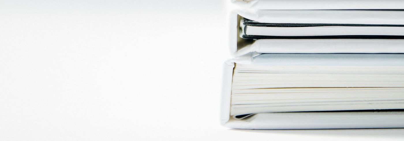 Drei weiße Aktenordner auf dem Tisch liegend