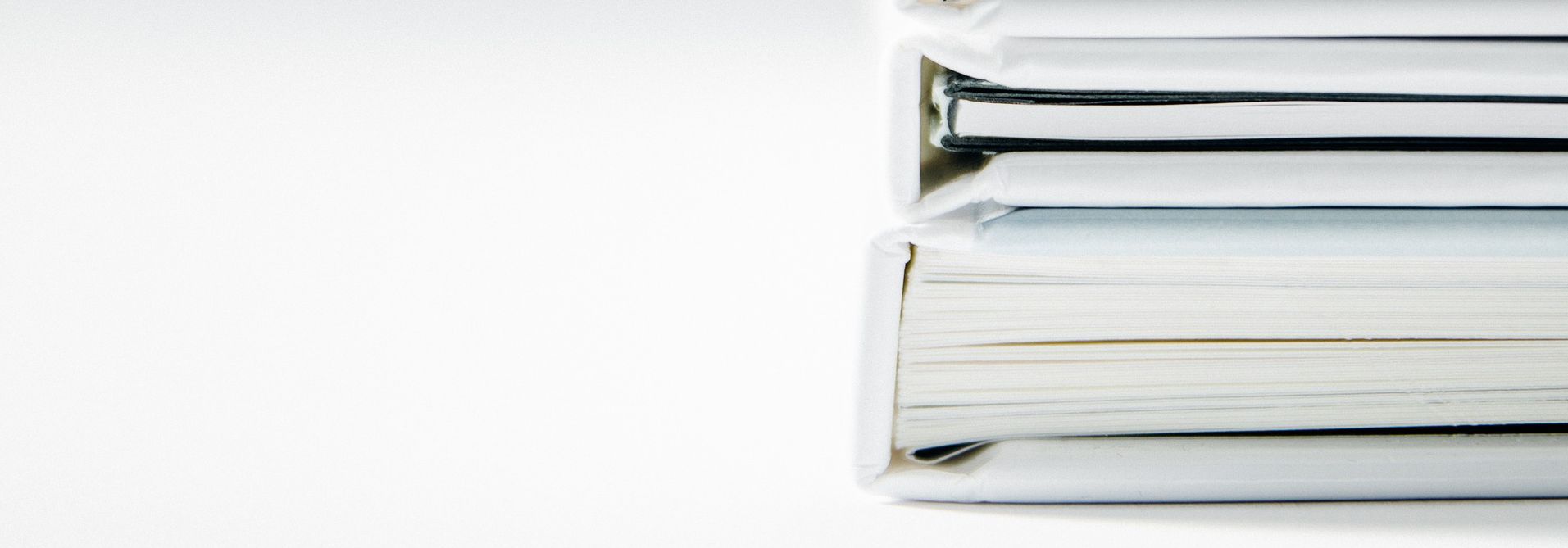 Drei weiße Aktenordner auf dem Tisch liegend