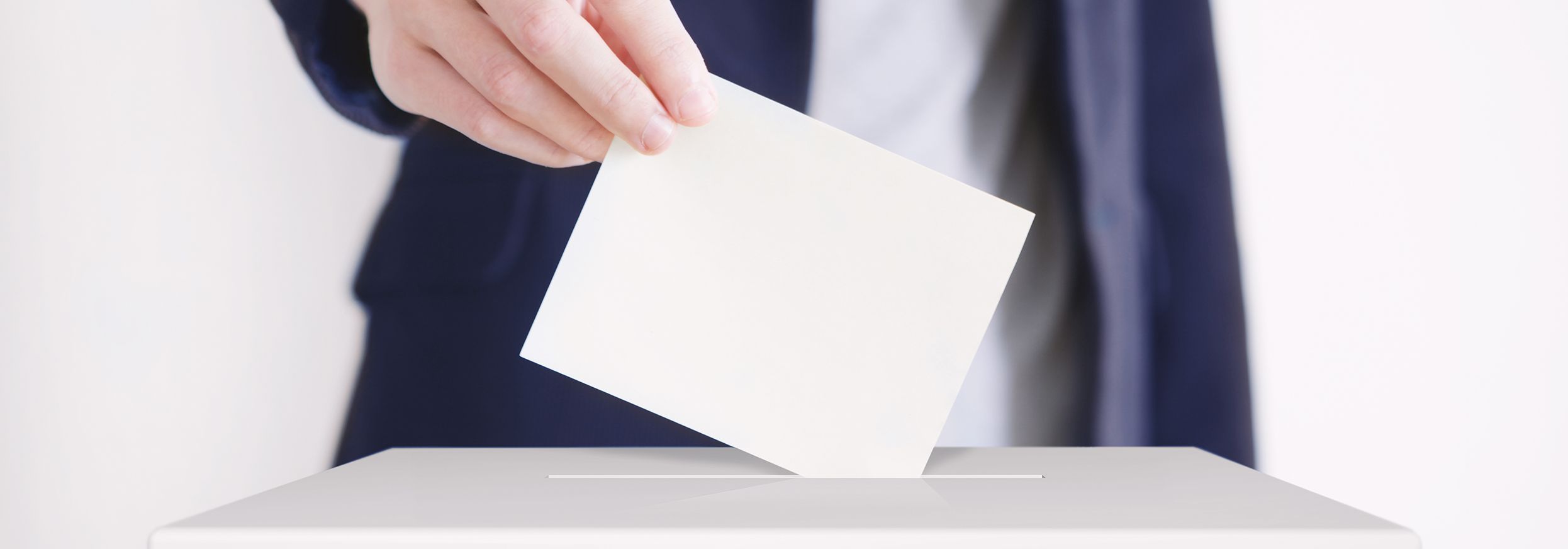 Mann, der einen Zettel in eine Wahlurne wirft